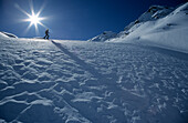 Schneestruktur mit Skitourengeher im Gegenlicht, Laschadurella, Graubünden, Schweiz