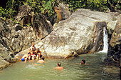 Tourists swim in the natural pool at the Na Muang waterfalls in the south of Koh Samui island, Thailand