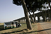 Archeobus in front of ancient aqueduct south of Rome, Rome, Italy