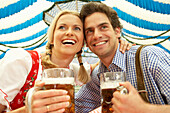 Laughing couple with liter of beer in a beer tent