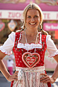 Mid adult woman wearing dirndl dress with a chocolate heart