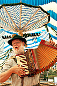Mann in bayrischer Tracht spielt Akkordeon