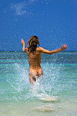 Frau, 20-30 Jahre, läuft nackt durch das Wasser am Strand, Karibik