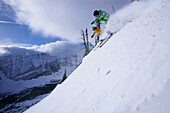 Two skiers skiing downhill, Castle Mountain ski resort, Alberta, Canada