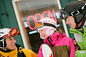 Three skiers in front of T-Bar pub, Bavaria, Germany