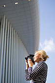 Young woman photographing Philarmonie, Luxembourg, Luxembourg