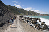 Wanderer am Red Rocks Coastal Walk, Owhiro Bay, nahe Wellington, Nordinsel, Neuseeland