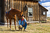 Cowboy mit Pferd vor Scheune, Wilder Westen, Oregon, USA