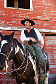 cowboy sitting on horseback with pistol, wildwest, Oregon, USA