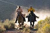 cowgirl and cowboy riding, Oregon, USA