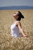 Mid adult woman meditating in a corn field, , Carinthia, Austria