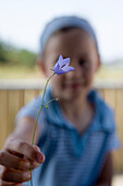 Mädchen überreicht einen Glockenblume, Insel Sylt, Schleswig-Holstein, Deutschland