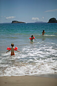 Mutter mit Töchtern (5 und 2,5 Jährige mit Schwimmhilfen), baden in Wellen am Hahei Beach, bei Hahei, Ostküste, Coromandel Peninsula, Nordinsel, Neuseeland