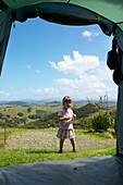 Mädchen im Zelteingang, Camping, an Schafweiden, Okopako Lodge, nahe Hokianga Harbour, Northland, Nordinsel, Neuseeland