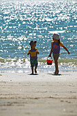 Zwei Mädchen (2-5 Jahre) laufen mit Eimern am Strand Kniepsand entlang, Wittdün, Insel Amrum, Nordfriesische Inseln, Schleswig Holstein, Deutschland