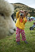 Mädchen fotografiert Schaf,  Okains Bay, Bank's Peninsula, Ostküste, Südinsel, Neuseeland