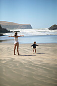 Mutter und Kind spielen am Strand der Little Okains Bay, flaches Wasser, Bank's Peninsula, Ostküste, Südinsel, Neuseeland
