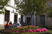 Leute sitzen im Café, Blumen im Vordergrund, Frühling, Altstadt, Santiago de Compostela, Galacien, Spanien