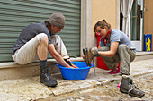 Zwei Pilger, Mann und eine Frau beim Putzen, Schuhe waschen vor der Pilgerherberge, Estella, Navarra, Spanien