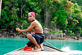 Einheimischer Mann steuert ein Longtailboot, Surin Islands Marine National Park, Ko Surin, Phang Nga, Thailand