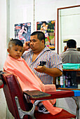 Friseur mit Kind, Junge, in Thai Muang, Phang Nga, Thailand