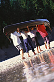 Group carrying a canoe, Sylvenstein lake, Bavaria, Germany