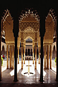 Löwenhof mit Brunnen und Arkaden mit schlanken Marmorsäulen im maurischen Fürstenpalast Alhambra, Granada, Andalusien. Spanien