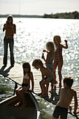 Children playing on the jetty, Lake Woerthsee, Upper Bavaria, Bavaria, Germany