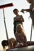 Children on jetty at Lake Woerthsee, girl smiling at camera, Bavaria, Germana, MR