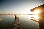A child playing on the jetty, Woerthsee, Upper Bavaria, Bavaria, Germany