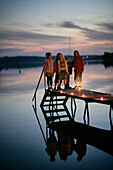 Children standing on jetty at Lake Woerthsee, Walchstadt, Bavaria, Germany, MR
