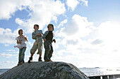 Drei Kinder auf einen großen Stein, Strand, Torekov, Skane, Schweden