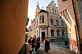 People, pedestrians walking down the street in fancy dress during medievel week, old town, Visby, Gotland, Sweden