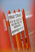 Sign on a fence of a private beach, North Sea, Germany