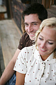 Young couple sitting on a bench, Heiligenblut, Hohe Tauern National Park, Carinthia, Austria