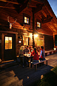 Group of young people in front of an alp lodge, Heiligenblut, Hohe Tauern National Park, Carinthia, Austria