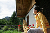 Frau sonnt sich vor einer, Almhütte, Heiligenblut, Nationalpark Hohe Tauern, Kärnten, Österreich