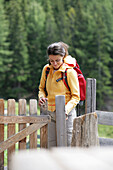 Woman passing a fence door, Heiligenblut, Hohe Tauern National Park, Carinthia, Austria