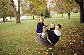 Children on tire swing. USA.