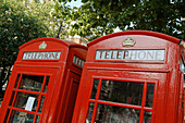 A typically British symbol: two bright red London telephone booths. England, UK