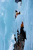 Ice climber on frozen waterfall, Iceland