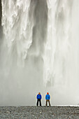 Two men stood in front of a waterfall, Iceland