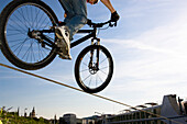 Man trial biking over a steel cable, Linz, Upper Austria, Austria
