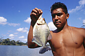 Man with piranha. Orinoco. Vanezuela.