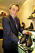 Mr. Brian Jones showing Church s men shoes in his shop. London. England