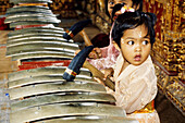 Child playing music at a gamelan (orchestra) Hinduist religious ceremony (odalan) in the Celuk Temple. Bali island. Indonesia
