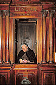 Priest in confessionnal waiting for sinners, San Giovanni in Laterano. Rome, Italy