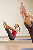 woman doing the open leg rocker, a pilates exercise