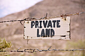 USA, New Mexico, Lordsburg. Private property sign on barbed wire fence at granite gap.