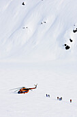 Group of skiers near a helicopter, Heliskiing, Kamchatka Peninsula, Sibiria, Russia